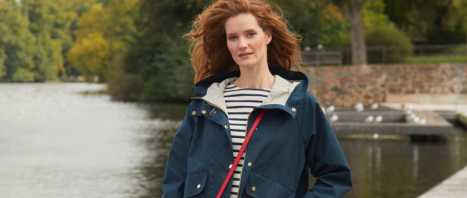 Frau in Regenjacke vor Teich